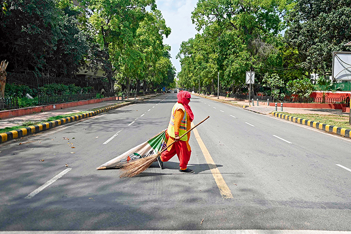 一名清洁工人穿过印度新德里一条马路 新华社/法新
